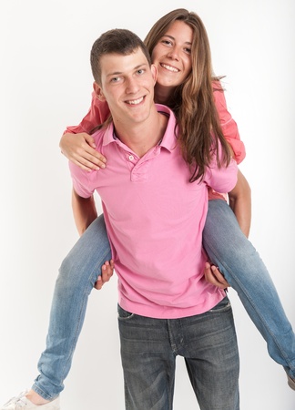 Young man carrying his girlfriend piggybackの写真素材