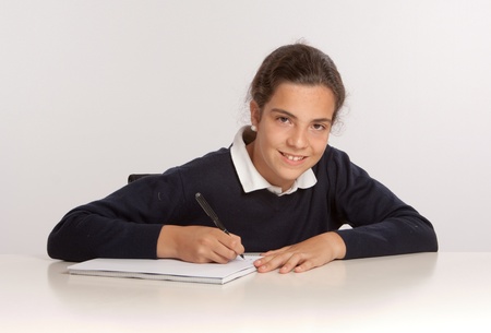 
Schoolgirl writing at her desk with a happy expression

の写真素材