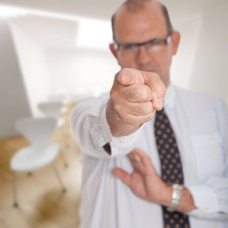 Angry man pointing to the camera in a conference roomの写真素材