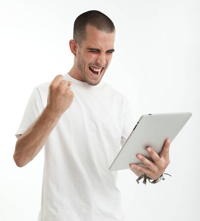 Young man having fun using a digital tabletの写真素材