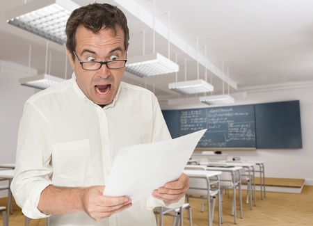 Horrified teacher reading a paperの写真素材