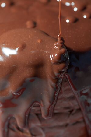 Melted chocolate falling on a cakeの写真素材