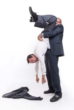 Big man holding another upside down by the anklesの写真素材