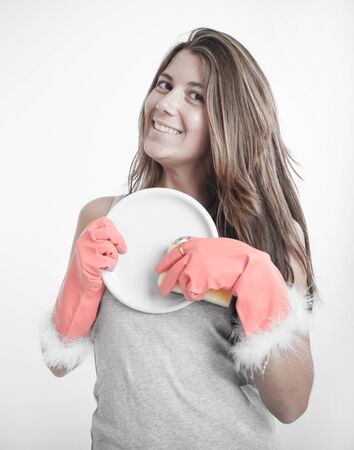 Young woman washing the dishes with glamorous glovesの写真素材