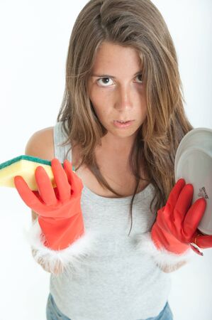 Young woman with an annoyed expression washing the dishesの写真素材