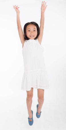 Cute little Asian girl happily jumpingの写真素材
