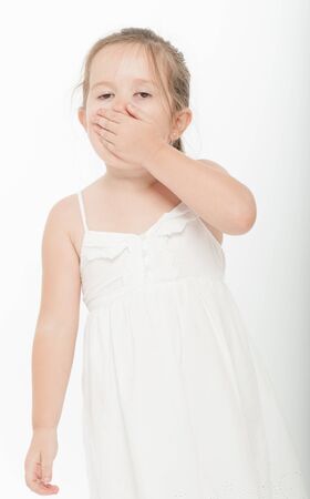 Cute little girl covering her mouth with her handの写真素材