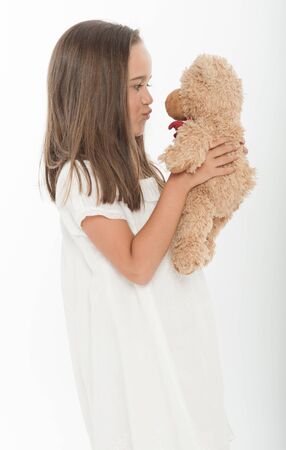 Cute little girl kissing a teddy bearの写真素材