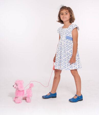 A cute little girl walking her toy dogの写真素材