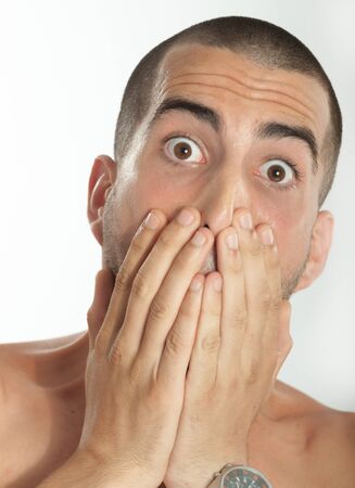 Young man covering his mouth with his handの写真素材