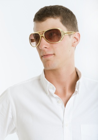 Young man wearing kitsch golden glassesの写真素材
