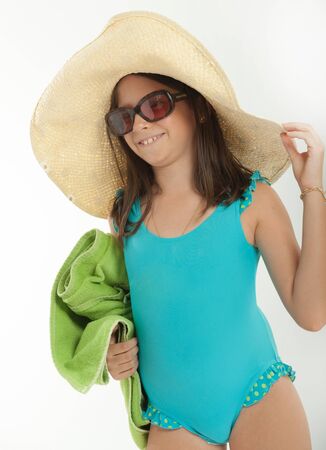 Young girl in swimsuit wearing a large hat and her moms sunglassesの写真素材