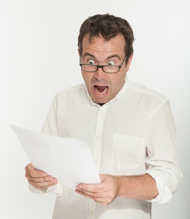 Man reading a document with an scared expressionの写真素材