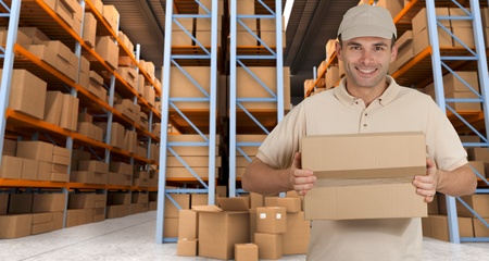 Deliveryman carrying a parcel in a distribution warehouseの写真素材