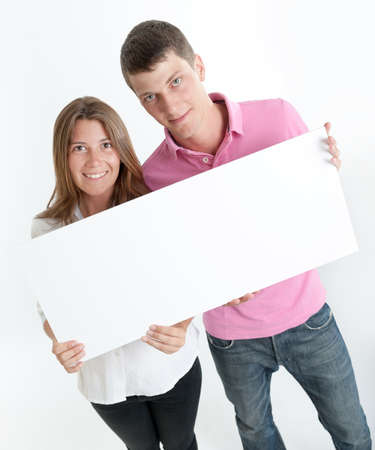 Young couple holding a blank board, ideal for inserting your own messageの写真素材