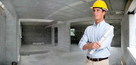 
An architect with a roll of blueprints inside a house in construction

の写真素材