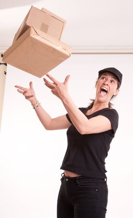 
Stressed female courier trying to catch falling parcels
の写真素材