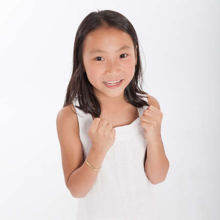 Cute little Asian girl with a victorious expressionの写真素材