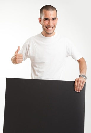 Young man holding a blackboard, with a happy expressionの写真素材