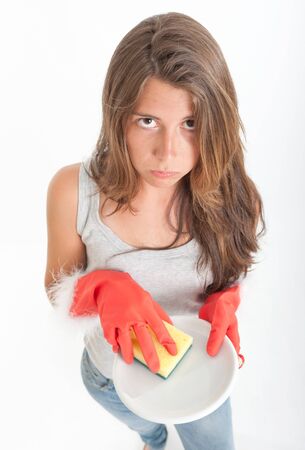 Young woman with an annoyed expression washing the dishesの写真素材