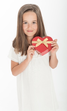 Little girl holding a heart shaped gift boxの写真素材