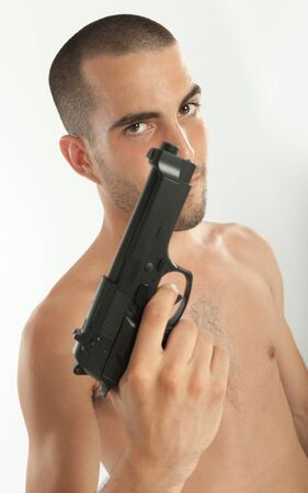 Bare-chested man holding a gunの写真素材