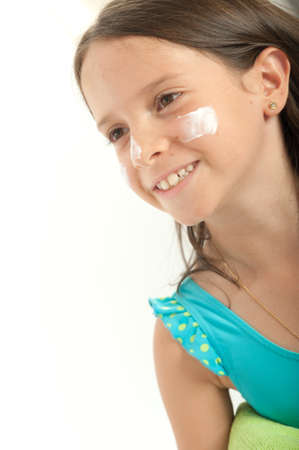 Mother applying sunscreen to her young girlの写真素材