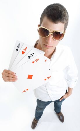 Young man holding four aces with kitsch golden sun glassesの写真素材