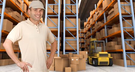 Deliveryman carrying a parcel in a distribution warehouseの写真素材