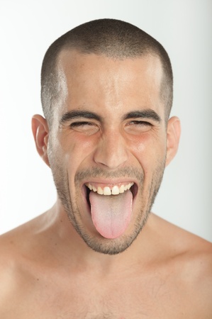 Portrait of a young man sticking his tongue outの写真素材
