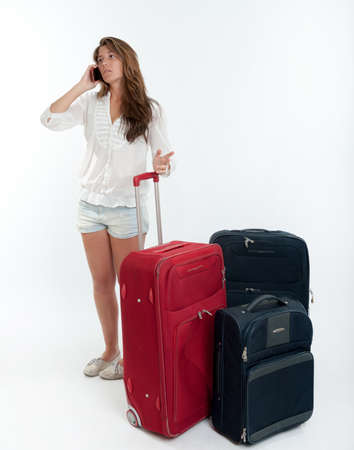 Young cute girl with luggage  talking on the phone の写真素材