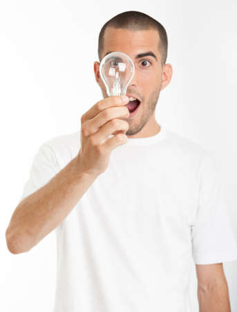 Man with a happy eureka expression holding a light bulbの写真素材