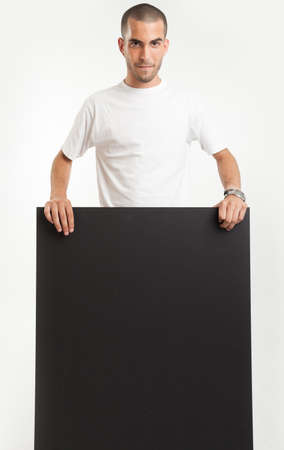 Young man holding a blackboard, with a happy expressionの写真素材