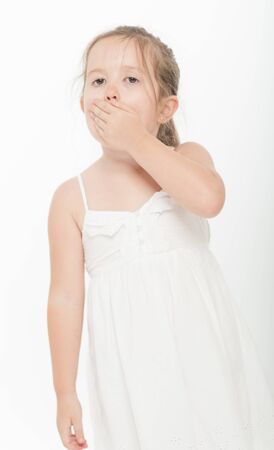 Cute little girl covering her mouth with her handの写真素材
