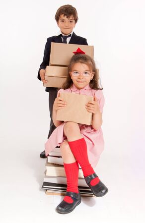 
A little boy and girl in school clothes with a pile of books and boxes
の写真素材