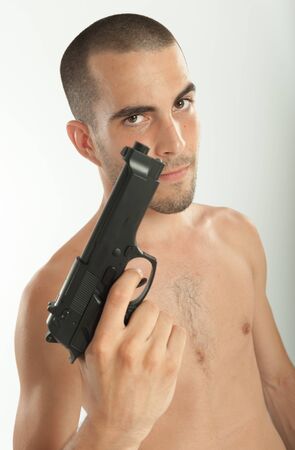 Bare-chested man holding a gunの写真素材