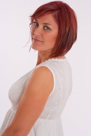 Portrait of a red haired woman wearing a white dressの写真素材