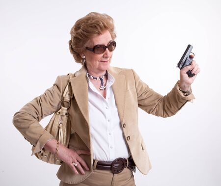
Mature lady with sunglasses and a gun in her hand
の写真素材