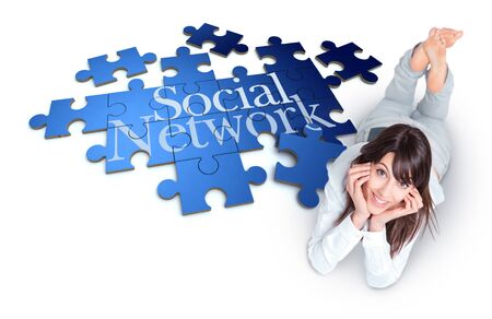 Young woman lying by a puzzle with the words Social Networkの写真素材