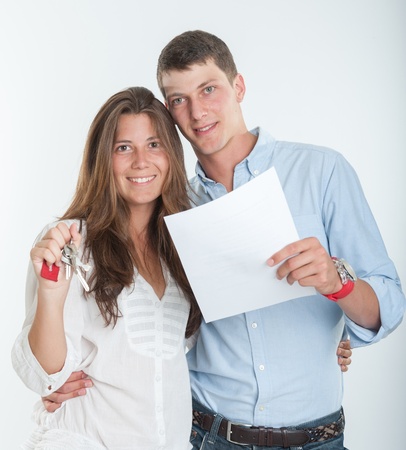 Young couple holding a document and a bunch of keysの写真素材