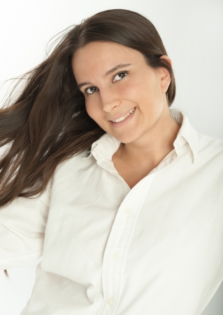 Smiling long haired brunette in a white shirtの写真素材