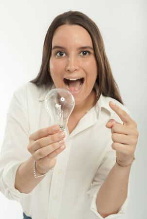 Woman holding a light bulb with a happy expressionの写真素材