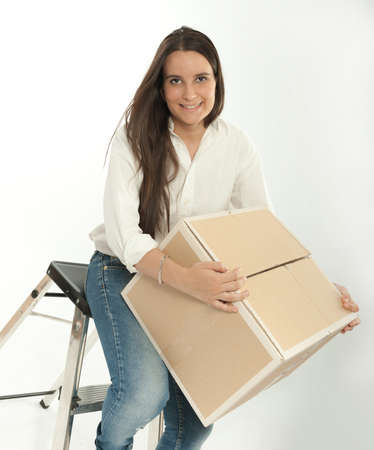 Young woman sitting on a ladder holding a cardboard box