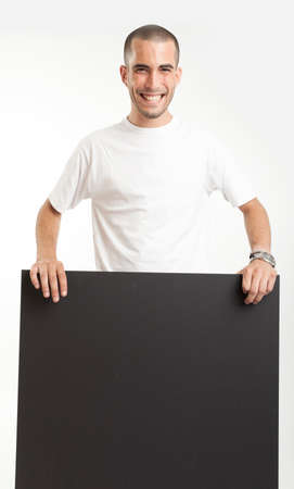 Young man holding a blackboard, with a happy expressionの写真素材