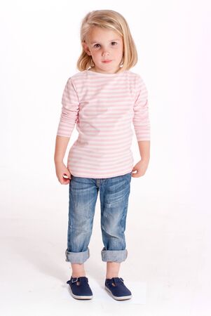 Cute little blonde girl in jeans and a stripped t-shirtの写真素材