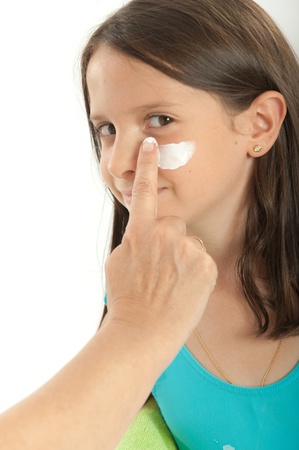 Mother applying sunscreen to her young girlの写真素材