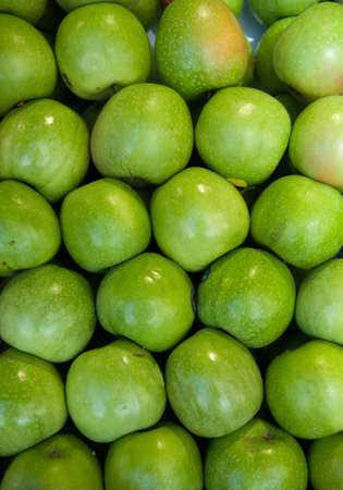 green apples on a market stall, ideal for backgroundsの写真素材