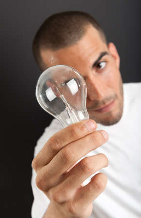 Man with a happy eureka expression holding a light bulbの写真素材