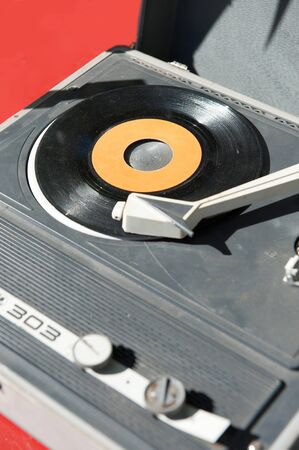 Old vintage portable  record player with a vinyl on itの写真素材
