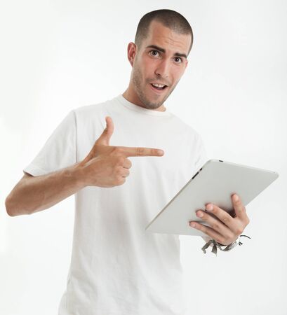 Serious looking young man with a digital tabletの写真素材